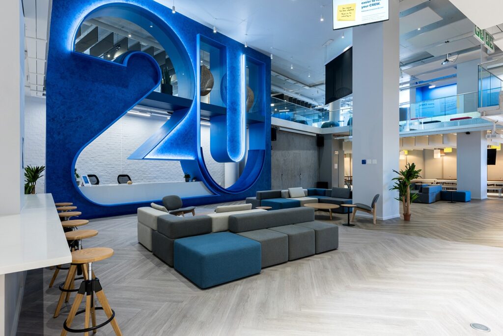 2U international commercial building reception area design and furnish with large branded signage with lighting