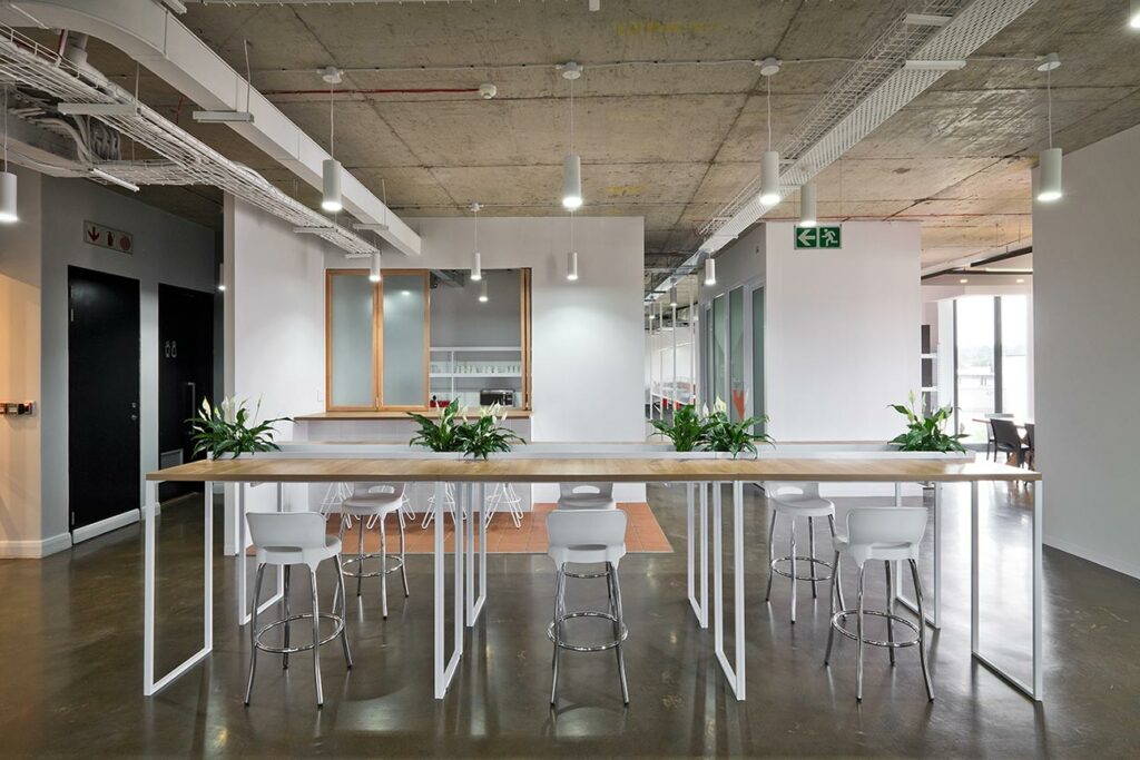 High table with stools and plants in open workspace for Aurik in Cape Town