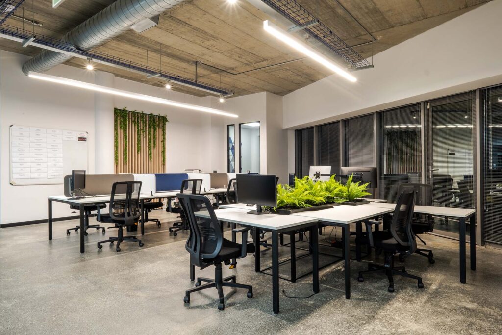 Mazars offices with industrial ceiling and modern lighting design with shared workspaces with plants for employee health
