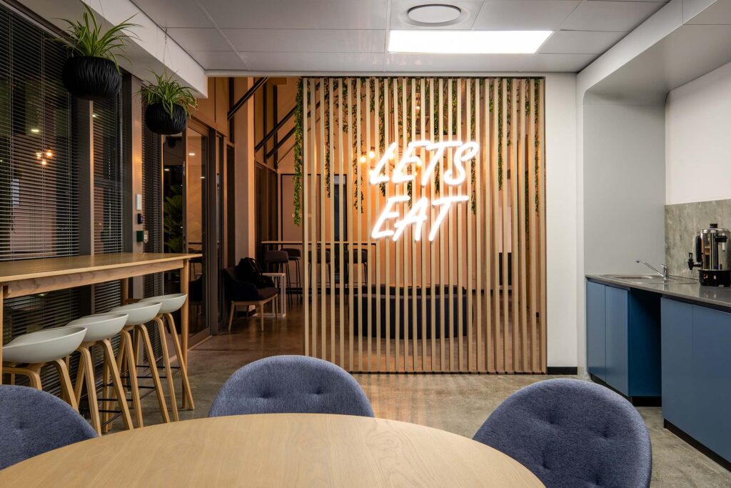 Mazars hi-tech interior design with led signage in canteen area with plants and wooden slats design